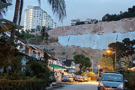 Prevention: Tarpaulin sheets covering a hill slope to stop erosion in Paya Terubong, Penang.